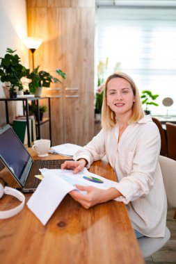 Odaklanmış bir insan rahat, yeşil bir ofiste evrak işleriyle ilgilenir..