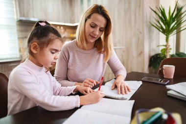 Anne ve kızı birlikte ödevlerini yaparken iyi vakit geçiriyorlar..
