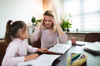 Bir anne, kızına ev ödevlerinde yardım etmek için mücadele eder, bunalmış hisseder..