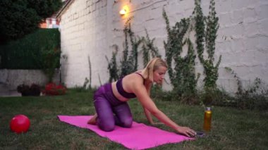 Sakin bir bahçe ortamında, kararlı bir anne sağlık ve anneliği dengeleyen bir fitness rutinine girişir. Akşam ışığının yumuşak parıltısı onun kişisel sağlığına olan bağlılığını yansıtıyor..