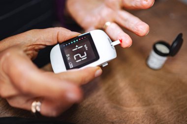 Evde kan şekeri seviyelerini glikoz sayacıyla kontrol ediyorum..