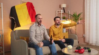 İki arkadaş favori takımı için tezahürat yaparken abur cubur ve içkinin tadını çıkarıyor..