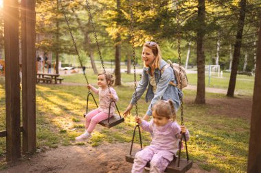 Annem parkta salıncakta ikiz kızlarını sallıyor..