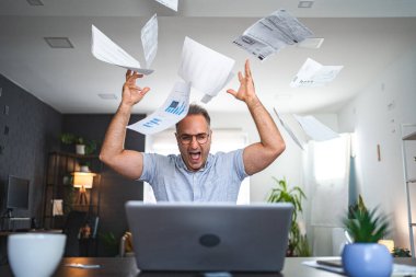 Evde çalışan hayal kırıklığına uğramış orta yaşlı, beyaz bir adam..