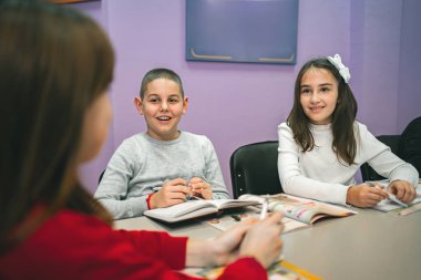 Bir grup ilkokul öğrencisi dil okulunda birlikte öğreniyor..