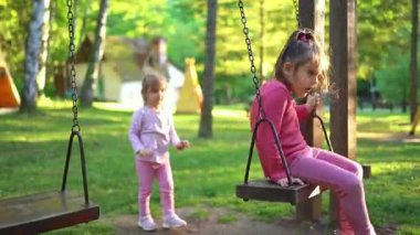 İki genç kız bir parkta güneşli bir öğleden sonranın keyfini çıkarırken, biri sallanıyor diğeri de etraflarındaki yeşilliği eğlenceli bir şekilde keşfediyor. Kahkaha ve neşe özgürce oynarken havayı doldurur..