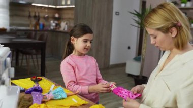 Genç bir kız ve annesi evde oyuncak bebeklerle yaratıcı oyunlar oynuyorlar..