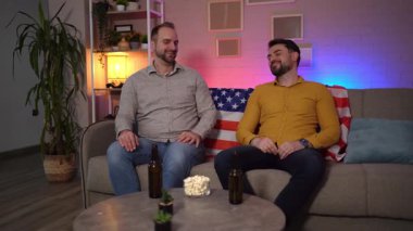 İki arkadaş kanepede rahatlar, içkinin ve sohbetin tadını çıkarırlar..