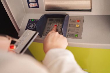 Bir kişi ATM 'ye bağlanır ve etkili bir şekilde para çekmeye hazırlanır..