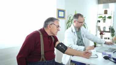 Yaşlı bir adamın tansiyonu ilgili bir doktora göre ölçülür..