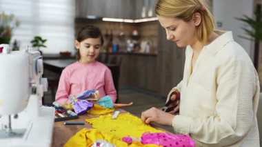 Anne ve kızı renkli kumaşlar dikerken el sanatları anlarına değer verin..