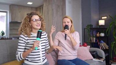 Arkadaşlar birlikte şarkı söyler ve gülerler. Evdeki neşeli karaoke gecesinde..