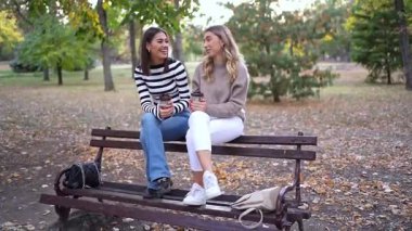 Dostlar renkli yaprakların arasında samimi bir sohbetin tadını çıkarırlar..