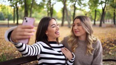 Arkadaşlar güz yaprakları arasında selfie çekerken gülüşlerini paylaşırlar..