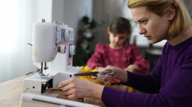Bir anne ve kız evde birlikte dikiş dikmekten zevk alır, hatıralar yaratır..