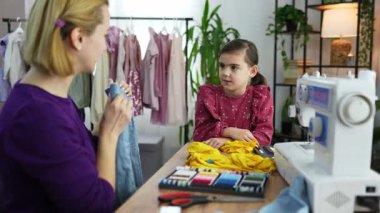 Bir çocuk, bir akıl hocasıyla dikiş öğrenirken zevk alır..