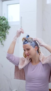 Bir kadın modern banyosuna renkli boya sürmekte ustadır..