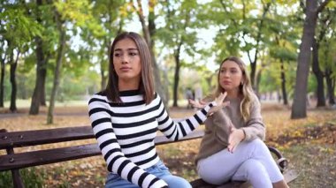 İki arkadaş bir bankta rahatlar, kahkahaların ve güzel bir sonbahar gününün tadını çıkarırlar..