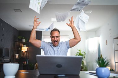 Evde çalışan hayal kırıklığına uğramış orta yaşlı, beyaz bir adam..