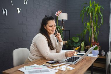 Gülümseyen kadın evde bilgisayardan alışveriş yapıyor..