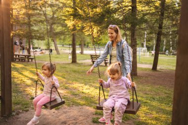 Annem parkta salıncakta ikiz kızlarını sallıyor..