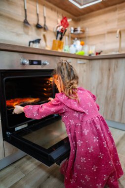 Parlak ve sıcak bir mutfakta, genç bir kız, çiçekli desenlerle süslenmiş pembe elbisesiyle fırına hevesle yaslanır. Ev yapımı bir yemeği paylaşmaya hazır bir yemeği getirdiğinde heyecan havayı dolduruyor..