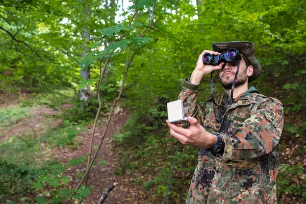 Askerler sık ormanda dürbün ve pusula kullanarak hayatta kalma becerilerini gösteriyor.