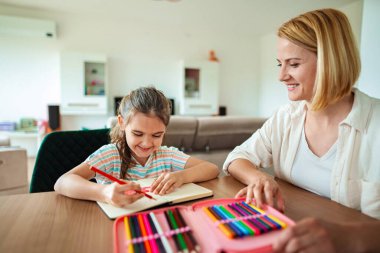 Genç kız boyamayı severken, annesi cesaret veriyor.