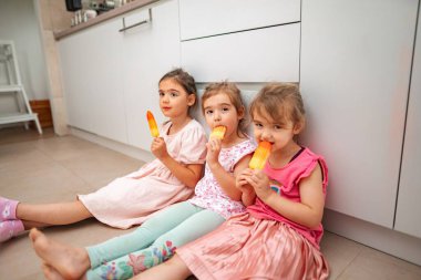 Küçük arkadaşlar sıcak bir günde ferahlatıcı buzlu içeceklerin tadını çıkarıyor.