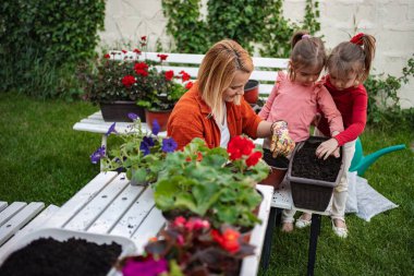 Bir anne bahçeyle ilgili eğlenceyi dışarıda kızlarıyla paylaşır..