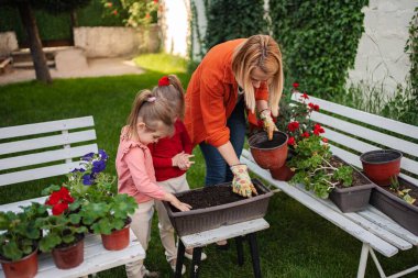 Işıl ışıl arka bahçelerinde iki genç kızla bir kadın..