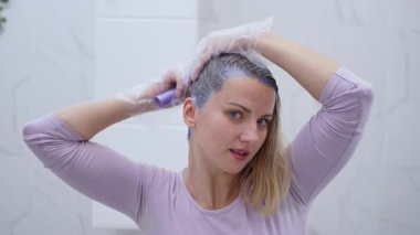 Bir insan değişime hazırlanırken canlı bir saç boyası sürüyor..