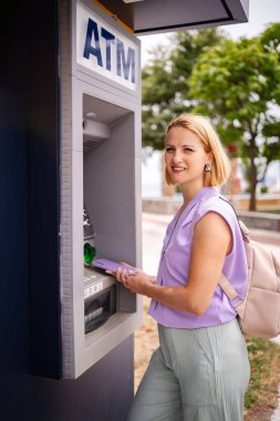 Kadınlar açık havada ATM kullanırken Yunanistan 'da yazın keyfini çıkarıyorlar.