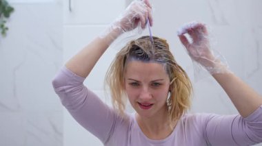 Modern, parlak bir banyoda canlı bir saç boyama seansı izleyin..