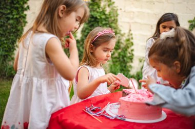 Küçükler doğum günü partisini kutlarken pastanın tadını çıkarırlar..