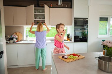 Ebeveyn rafları düzenlerken çocuk taze malzemelerin keyfini çıkarıyor.