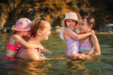 Sıcak denizde oynarken aile üyeleri arasında paylaşılan keyifli anlar.