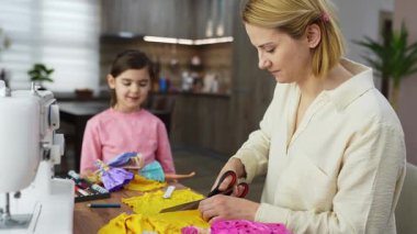 Anne ve kızı birlikte renkli kıyafetler dikmeyi severler..