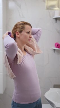 Kadın saçlarını nazikçe şekillendiriyor, sakin bir yerde kendine özen gösteriyor..