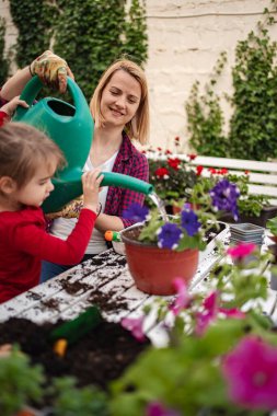 İki bahçıvan çiçekleri beslerken kaliteli zaman geçirirler..