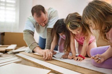 Bir baba, odaklanma ve işbirliği gerektiren bir proje üzerinde çalışırken üç kızına evde eğlenceli bir zanaat faaliyetinde rehberlik eder. Kahkaha, yaratıcı oyunları sırasında havayı doldurur..