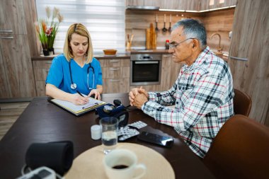 Bir sağlık uzmanı evdeki bir hastayı kontrol ediyor..