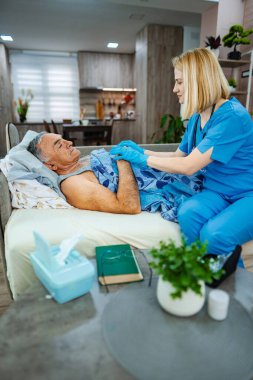 Hemşire evde bulunan bir hastaya özen gösterir..