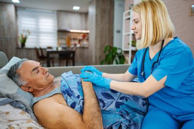 Bakıcı, rahat bir evde yaşlılara yardım eder..