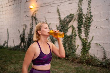 Yeni anne doğal ortamda egzersiz yaparken ferahlatıcı içeceklerden hoşlanır..