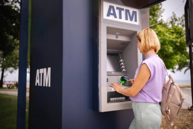 Bir gezgin Yunanistan 'daki açık hava ATM' sinden para çekiyor.