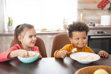 Mutfak masalarında kahvaltı eden iki çocuk..