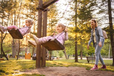 Annem parkta salıncakta ikiz kızlarını sallıyor..