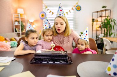 Çocuklar heyecan ve neşe dolu lezzetli bir pastanın etrafında toplandılar..