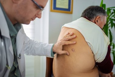 Tıbbi uzman, klinikte otururken hastaları muayene eder..